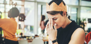 Stressed and upset woman at party wearing a paper crown