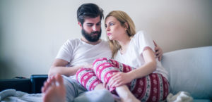 Worried young couple siting on the bed in the morning